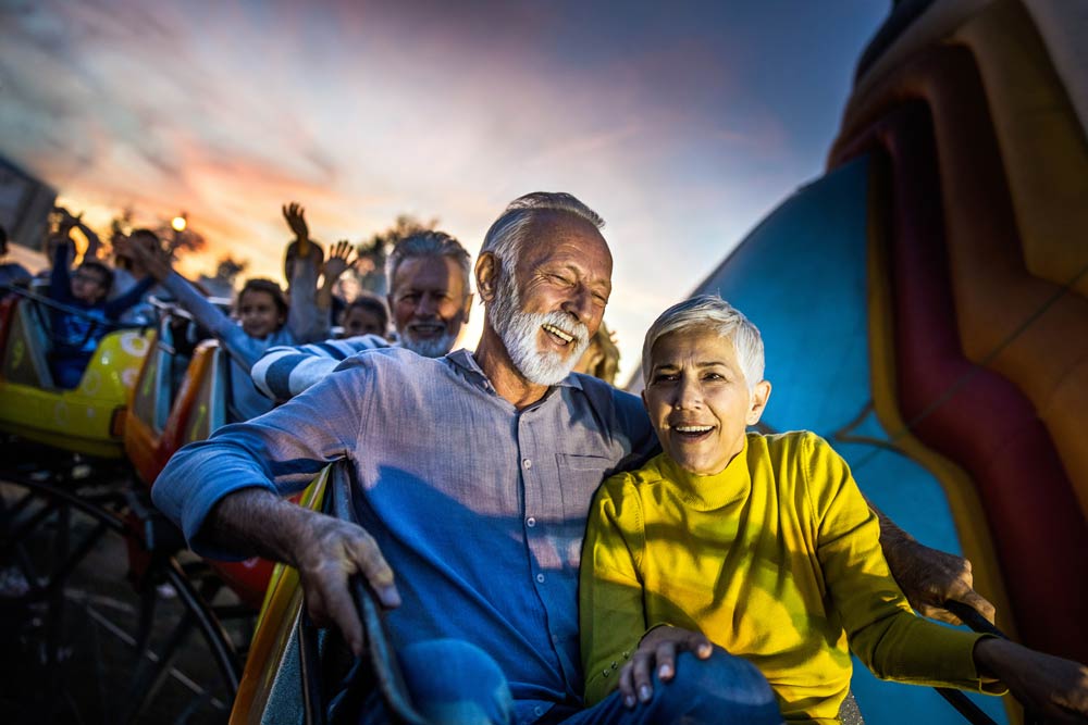 Ett äldre par som har kul ihop när de åker berg- och dalbana.